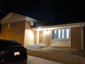 een huis waar 's nachts een auto voor geparkeerd staat bij Spacious 5 bedroom single family home sleeps 12 with driveway near DC in Bethesda