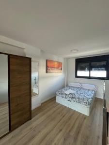 a bedroom with a bed and a wooden floor at A&R Atico Duplex Luxury II in San Sebastián de los Reyes +39 photos