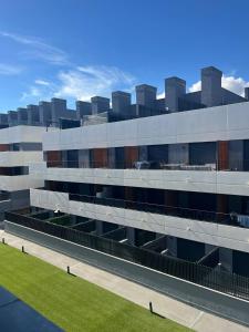 an external view of a building with a green lawn at A&R Atico Duplex Luxury II in San Sebastián de los Reyes