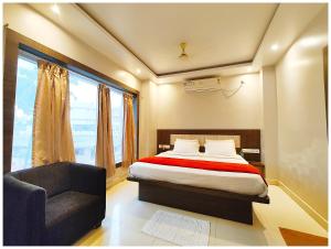 a bedroom with a bed and a chair and a window at Hotel Shreemahavia Home # Town Near Jagannath Temple and Sea Beach -Fully Air conditioned - Lift Wifi- And Parking Facilities -Excellent Customer Service Awarded -Best Seller in Puri +28 photos