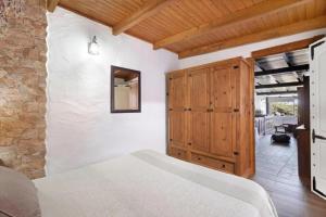 een slaapkamer met een bed en een houten kast bij Apartamento en El Hierro comodo y con Estilo in Tesbabo