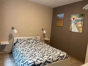 een slaapkamer met een bed en een schilderij aan de muur bij L'évasion in Bouillon