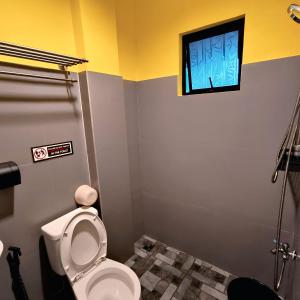 ein Badezimmer mit Toilette und Fenster in der Unterkunft DK's Inn in Coron + 34 Fotos