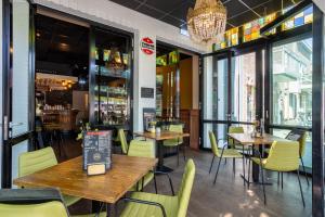 a restaurant with wooden tables and yellow chairs at Hotel Hulsman in Venray