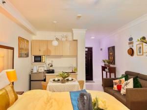 sala de estar con sofá, mesa y cocina en Attractive studio with Luxury bed Good for 1-4pax High speed WiFi with Netflix Free Pool & Parking, en Suba