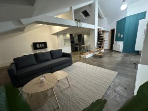 un soggiorno con un divano e un tavolo di Appartement loft proche frontières a Longlaville Altre 6 foto