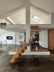 un soggiorno con mobili in legno e una scala a chiocciola di Appartement loft proche frontières a Longlaville