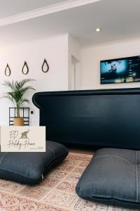 a black couch in a living room with a sign at ED Holiday Home- Chobe in Lesoma