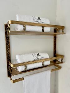 a stack of towels on a gold shelf in a bathroom at ED Holiday Home- Chobe in Lesoma +13 photos