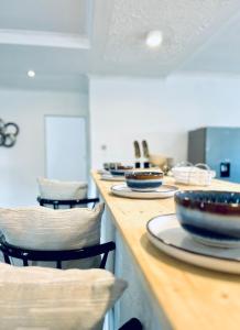 a counter with plates and bowls on top of it at ED Holiday Home- Chobe in Lesoma +13 photos