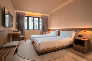 a hotel room with a large bed and a desk at Akeah Porto Centro in Porto