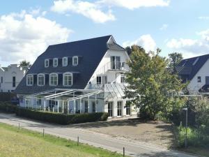 a large white house with a gambrel roof at BERNSTEINHAUS in Zingst barrierefreie 2-Raum-Wohnung mit Terrasse - Nr 1 in Zingst