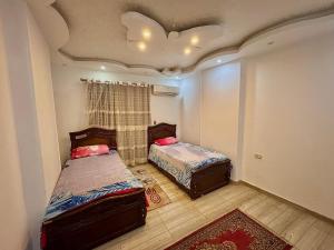a bedroom with two beds in a room with a ceiling at Nile House in Maadi N4 in Cairo