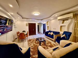 a living room with blue couches and a tv at Nile House in Maadi N4 in Cairo