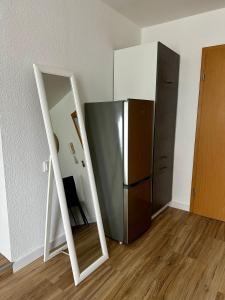 a mirror in front of a refrigerator in a room at Gemütliche, frisch renovierte Monteur-& Ferienwohnung in Egeln in Egeln