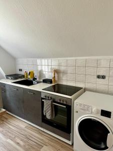 a kitchen with a stove and a washing machine at Gemütliche, frisch renovierte Monteur-& Ferienwohnung in Egeln in Egeln