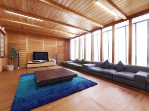 a living room with a couch and a tv at Yubaraonsen Yubaranoyado Komeya in Maniwa