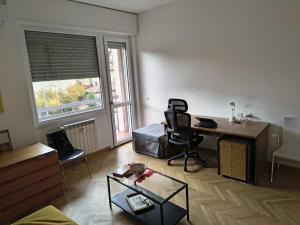 un soggiorno con scrivania e sedia di Bagaini Urban Flat a Varese Altre 7 foto