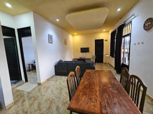 a living room with a wooden table and chairs at Villa Marion in Muanda