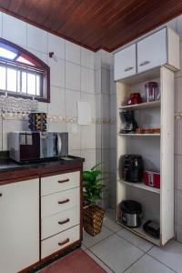 a kitchen with white cabinets and a counter top at Casa Top Arraial - Grupos e Famílias - 20 pessoas - 400 metros da praia in Arraial do Cabo