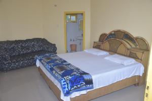 een slaapkamer met 2 bedden en een bank bij Sahil cottage in Chamba