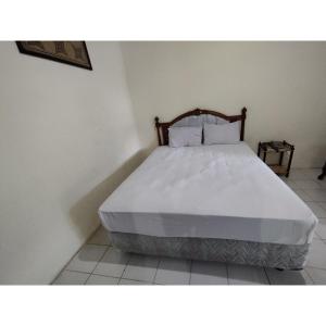 a bedroom with a bed with a white bedspread at Hotel O Wisma Bunda Syariah Near Man Pinrang in Salo