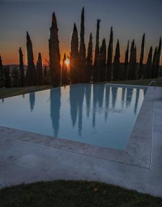 uma piscina com um pôr-do-sol ao fundo em Agriturismo Sant'Alfredo em Monteroni dʼArbia