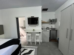 ケープタウンにあるThe Noble Lodgeのベッド1台、キッチン(デスク付)が備わります。