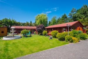 ダルウォボにあるDomki Forest sauna jacuzzi balia Darłowo Darłówko Ruskoの建物と公園のある広い庭