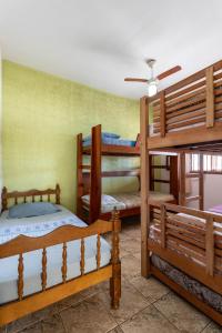 a room with three bunk beds and a ceiling fan at Casa Top Arraial - Grupos e Famílias - 20 pessoas - 400 metros da praia in Arraial do Cabo