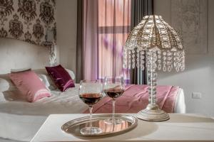 due bicchieri di vino su un tavolo accanto al letto di Rome Visits a Roma