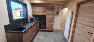 a kitchen with a sink and a large window at Gîtes des Deux Sapins 