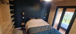 a bedroom with a bed and a blue wall at Gîtes des Deux Sapins 