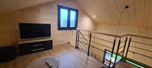 a room with a television and a staircase in a house at Gîtes des Deux Sapins 