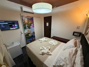 a room with a bed with bows on it at Pousada Vila Italia - Porto da Dunas in Aquiraz