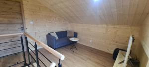 a room with a blue couch in a wooden room at Gîtes des Deux Sapins  +22 photos