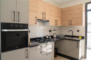 アガディールにあるAgadir Bay Dream Stayの木製のキャビネットと黒い家電製品を備えたキッチン