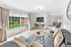 una sala de estar con un sofá y una mesa en The Ridge Residence - Luxury 4 Bed Near Warner Bro Studios With Parking, en Leavesden Green