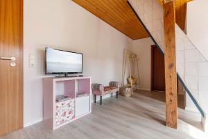un salon avec une télévision et un escalier dans l'établissement Apfel, à Westermarkelsdorf