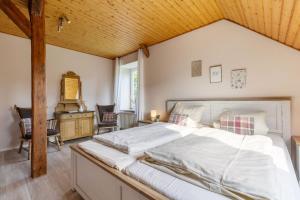 une chambre avec un grand lit avec un plafond en bois dans l'établissement Apfel, à Westermarkelsdorf 14 autres photos