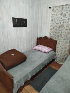 a small bedroom with a bed and a couch at Quarto com duas Camas Individuais in Gramado
