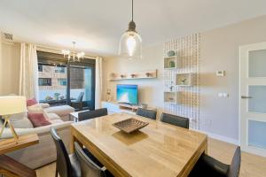 a dining room and living room with a table and chairs at Alma de Pacifico in Málaga