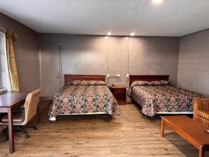 a room with two beds and a table and a desk at Walkers Inn by Hotel O Dothan US 84 in Dothan