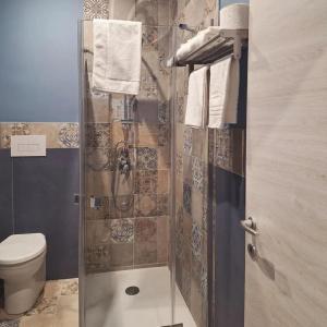 a bathroom with a shower with a toilet and towels at Luppolo Amaro in Sommatino