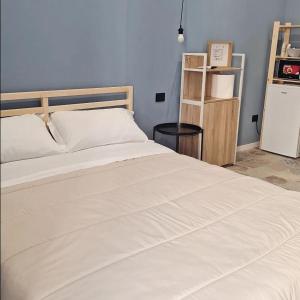 a bedroom with a large white bed and a refrigerator at Luppolo Amaro in Sommatino