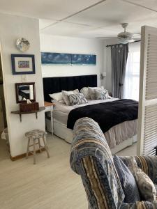 a bedroom with a bed and a chair and a couch at Constantia Lazy River in Cape Town