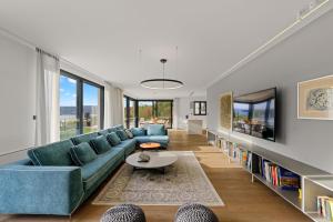 a living room with a blue couch and a tv at Villa Adria Blue in Bakarac