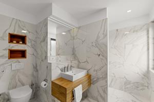 a white bathroom with a sink and a toilet at Villa Adria Blue in Bakarac