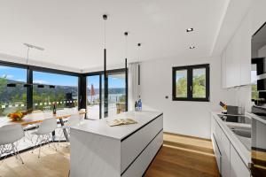 a kitchen with white cabinets and a table with chairs at Villa Adria Blue in Bakarac
