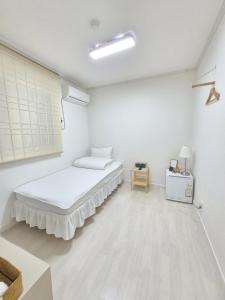 a white room with a bed and a table at Blau Guesthouse in Gyeongju +54 photos
